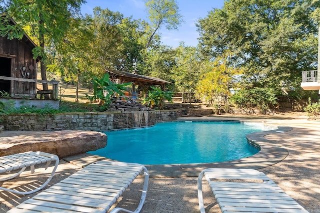 outdoor pool featuring fence and a patio