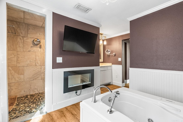 bathroom with a wainscoted wall, visible vents, and a glass covered fireplace