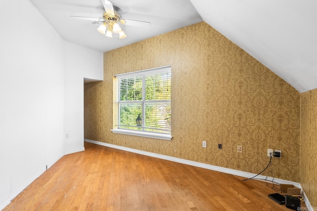 bonus room featuring lofted ceiling, wallpapered walls, and wood finished floors