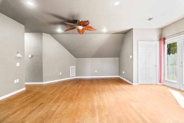 additional living space with lofted ceiling, visible vents, a ceiling fan, light wood-type flooring, and baseboards