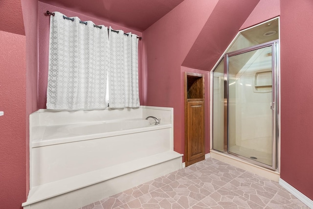 bathroom with a stall shower, baseboards, vaulted ceiling, and a bath