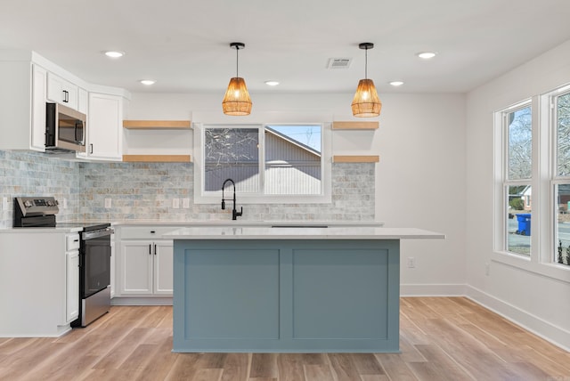 kitchen with stainless steel appliances, open shelves, visible vents, and white cabinets