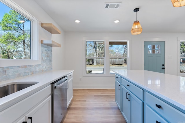 kitchen featuring dishwasher, tasteful backsplash, a wealth of natural light, and visible vents