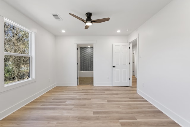 unfurnished room featuring light wood-type flooring, visible vents, baseboards, and recessed lighting