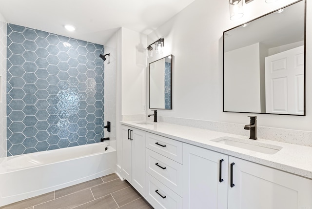 bathroom featuring double vanity, shower / bathing tub combination, and a sink