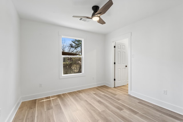 unfurnished room with ceiling fan, light wood finished floors, visible vents, and baseboards