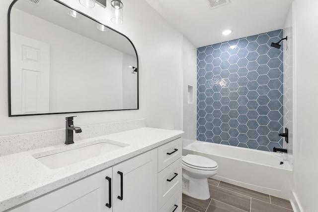 bathroom featuring toilet, bathing tub / shower combination, wood finish floors, and vanity