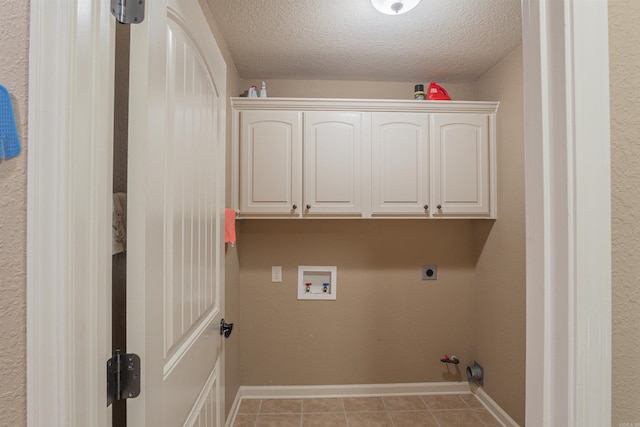 washroom with a textured ceiling, washer hookup, and baseboards