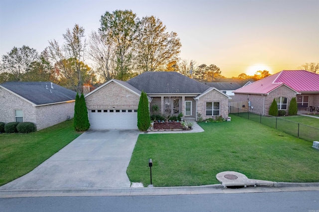 ranch-style house featuring driveway, a lawn, an attached garage, fence, and brick siding