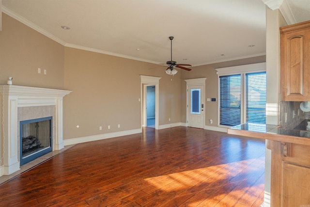 unfurnished living room featuring ornamental molding, wood-type flooring, a fireplace, and baseboards