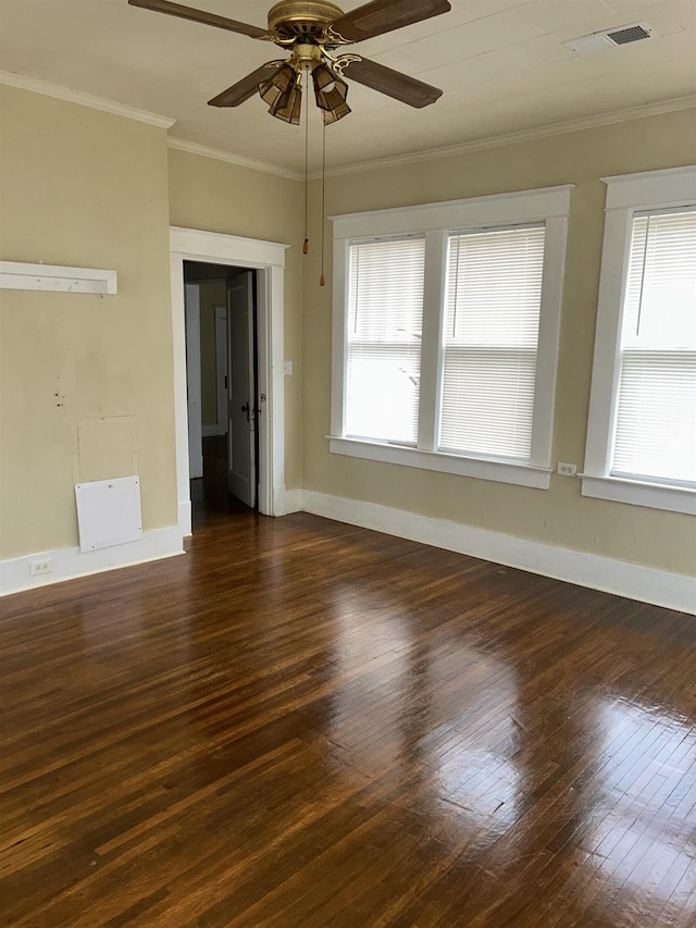 unfurnished room with ceiling fan, visible vents, baseboards, dark wood finished floors, and crown molding