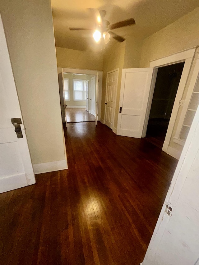 hallway featuring baseboards and hardwood / wood-style floors