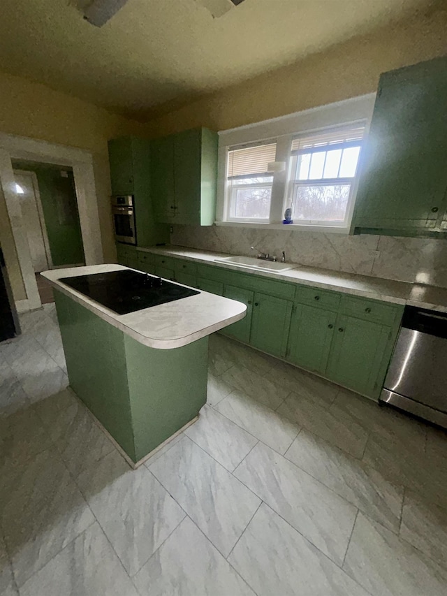 kitchen featuring a sink, marble finish floor, appliances with stainless steel finishes, light countertops, and green cabinetry