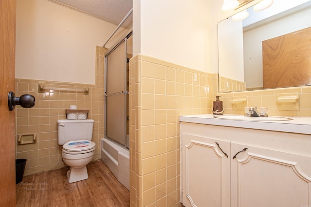 681 Sharp Ave, Camden, AR 71701 - full bath with tile walls, wood finished floors, vanity, combined bath / shower with glass door, and wainscoting