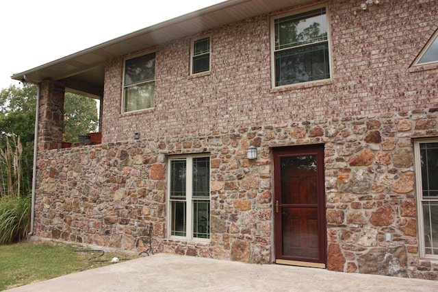 rear view of house with stone siding and brick siding