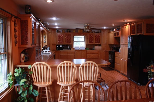 708 Kid Phillips Rd, Marshall, AR 72650 - kitchen featuring light wood-style floors, glass insert cabinets, a peninsula, black appliances, and a sink