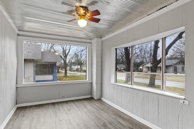 unfurnished sunroom with a healthy amount of sunlight and ceiling fan