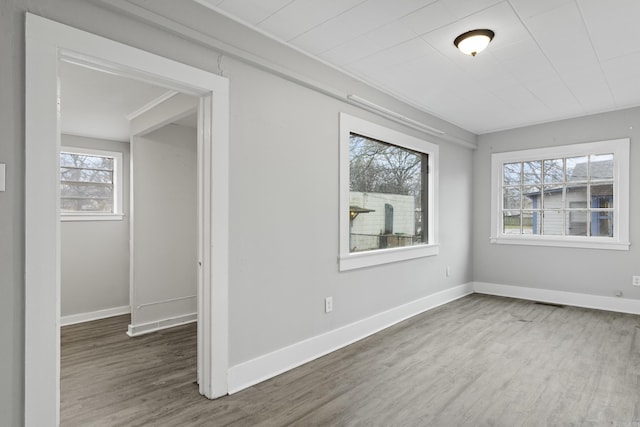 unfurnished room with baseboards and wood finished floors