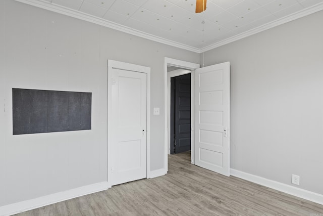 unfurnished bedroom with baseboards, ornamental molding, ceiling fan, and wood finished floors