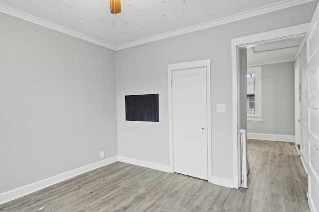 unfurnished bedroom featuring ornamental molding, baseboards, and wood finished floors