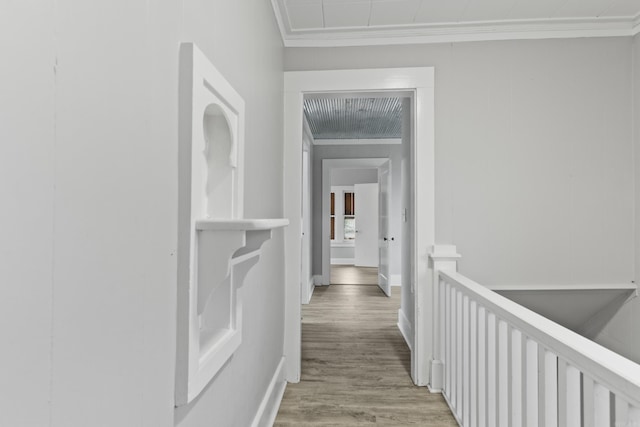 hallway with crown molding, baseboards, and wood finished floors