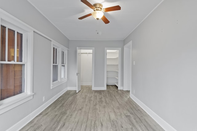 unfurnished bedroom featuring a ceiling fan, baseboards, and wood finished floors