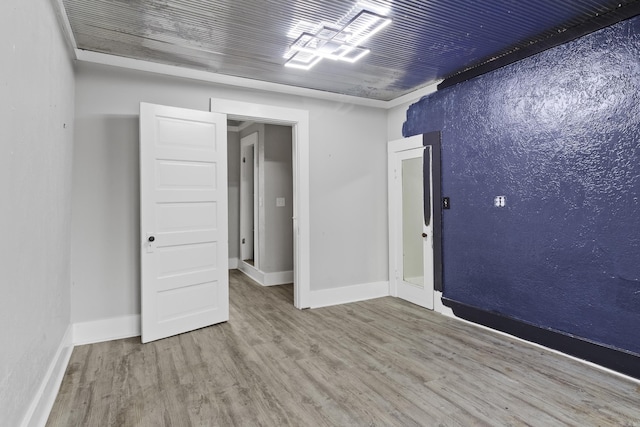 spare room featuring wood ceiling, baseboards, and wood finished floors