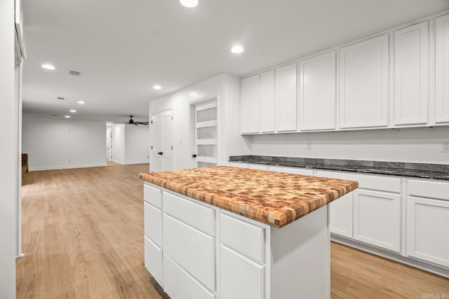 kitchen featuring light wood-type flooring, a kitchen island, white cabinetry, and recessed lighting