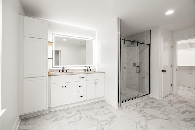 full bathroom with marble finish floor, a spacious closet, a sink, and a marble finish shower