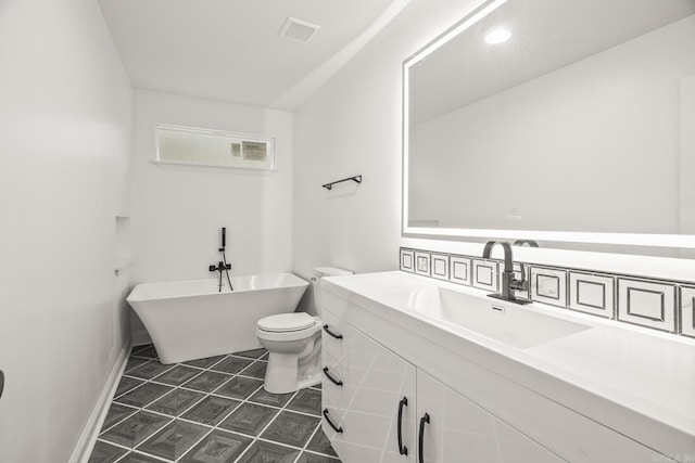 bathroom featuring toilet, vanity, visible vents, a soaking tub, and tile patterned floors