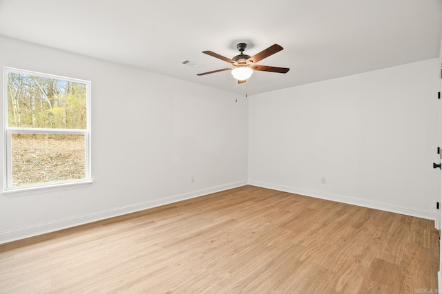 unfurnished room featuring baseboards, ceiling fan, visible vents, and light wood-style floors