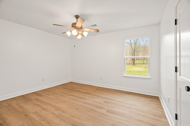 empty room with light wood-type flooring, visible vents, and baseboards