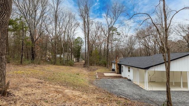 view of yard featuring a patio area and gravel driveway