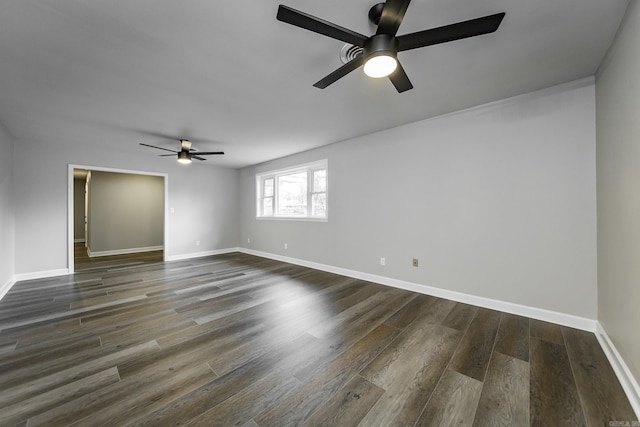 spare room with a ceiling fan, baseboards, and dark wood-style flooring