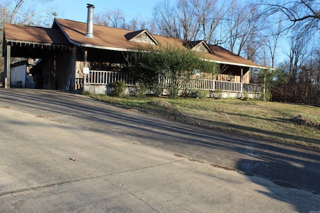 view of front of house with aphalt driveway, a porch, and a carport