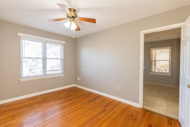 spare room with light wood-style flooring, baseboards, and ceiling fan