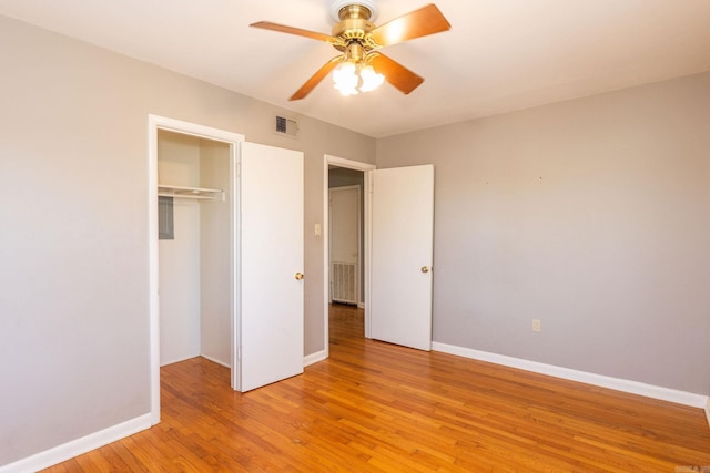 unfurnished bedroom with baseboards, visible vents, ceiling fan, light wood-style floors, and a closet