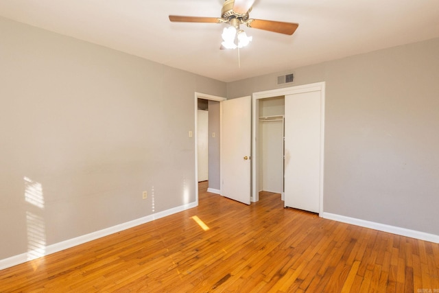 unfurnished bedroom with a closet, visible vents, light wood-style floors, a ceiling fan, and baseboards