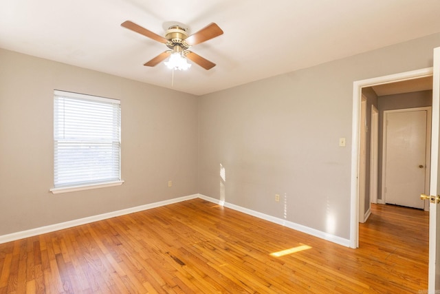 empty room featuring a ceiling fan, light wood-style flooring, and baseboards