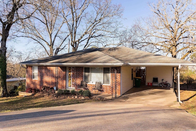 ranch-style home featuring driveway, brick siding, a porch, and an attached carport