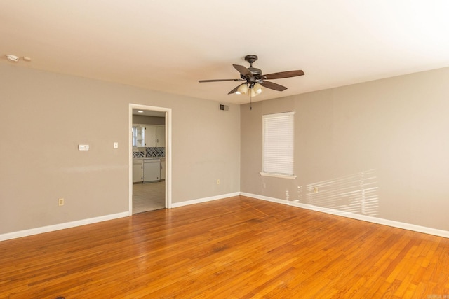 unfurnished room with light wood-type flooring, baseboards, and a ceiling fan