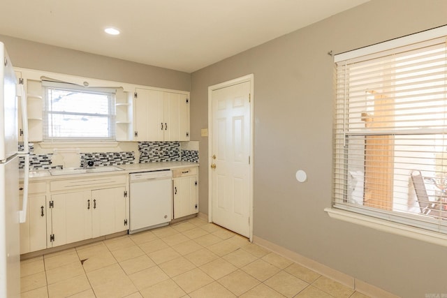 kitchen featuring open shelves, light countertops, decorative backsplash, a sink, and dishwasher