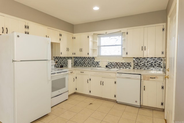 kitchen featuring white appliances, decorative backsplash, light countertops, and a sink