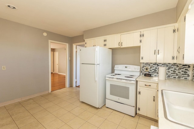 kitchen with white appliances, tasteful backsplash, light tile patterned floors, light countertops, and a sink