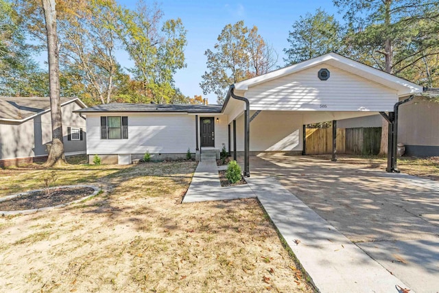 single story home with a carport, concrete driveway, and fence