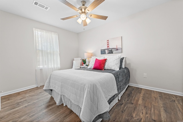 bedroom with a ceiling fan, baseboards, visible vents, and wood finished floors