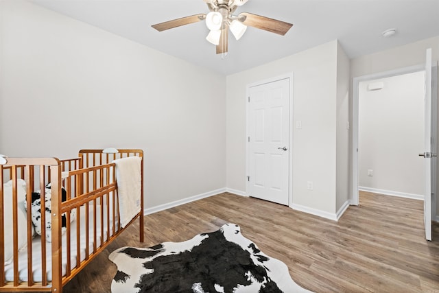 bedroom featuring a ceiling fan, baseboards, and wood finished floors