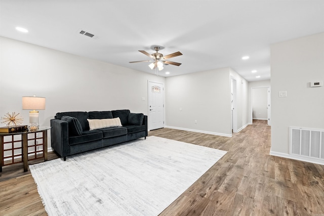 living room featuring recessed lighting, visible vents, baseboards, and wood finished floors