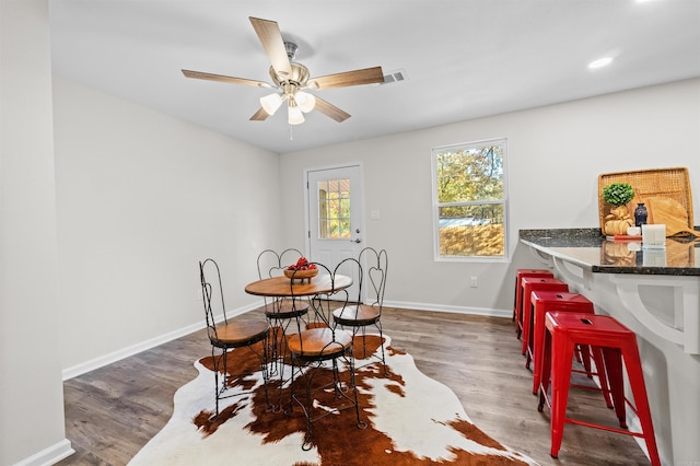 dining room with ceiling fan, wood finished floors, visible vents, and baseboards