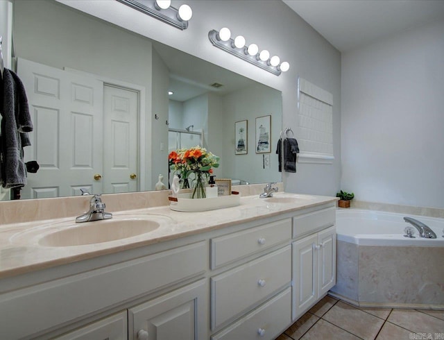 full bath with double vanity, a garden tub, tile patterned flooring, and a sink